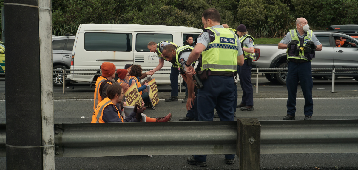 Police stand by protesters at Melling station as drivers watch on.